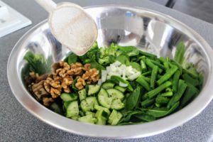 A bowl filled with veggies before mixing the ingredients together.