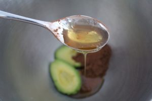 Honey dripping into a bowl of avocado's and cocoa powder. 